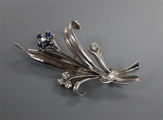 A white metal sapphire and diamond set floral spray brooch, 55mm.